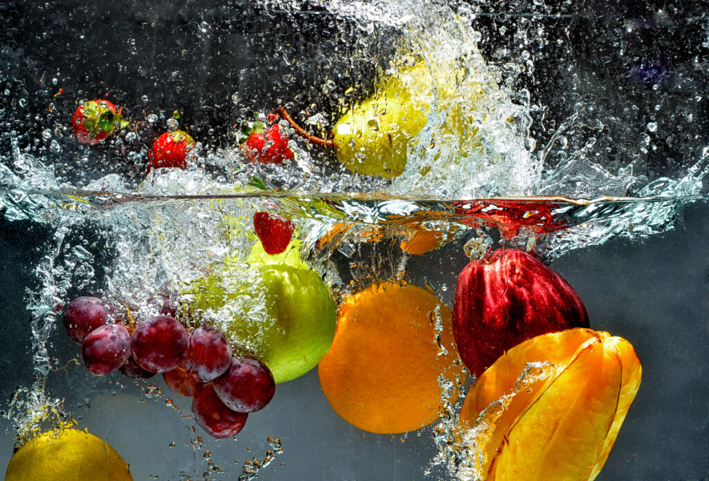 Fresh fruit and vegetables being dropped into water