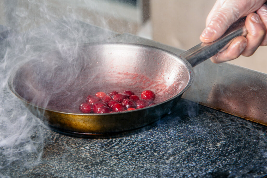 Sauteed cherries in a copper pan