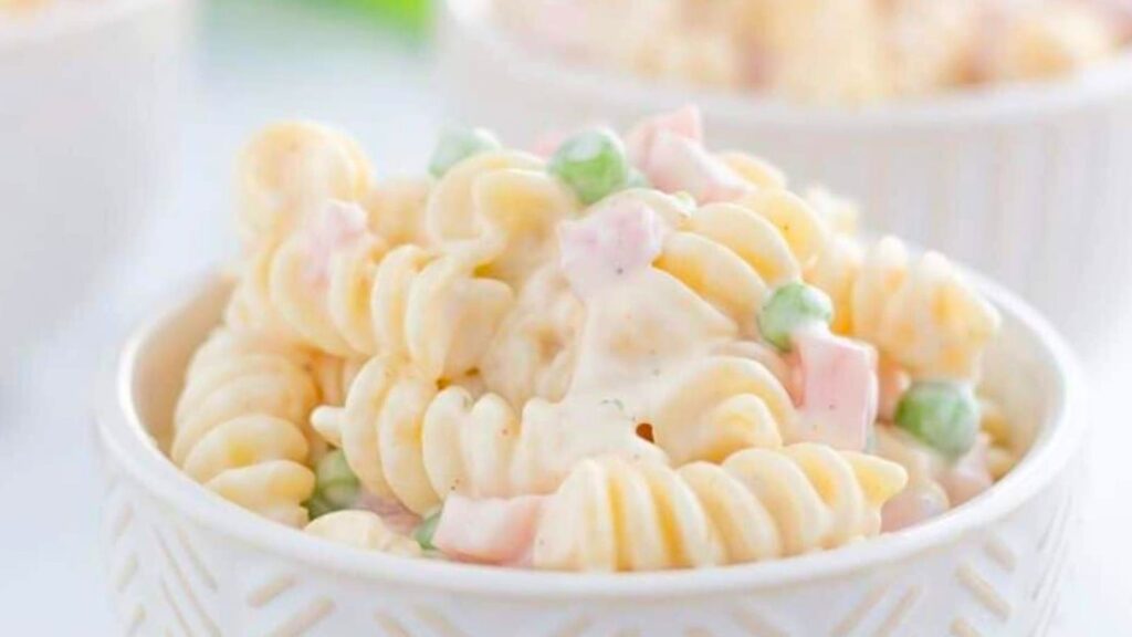 A white bowl with spiral pasta with peas and ranch dressing