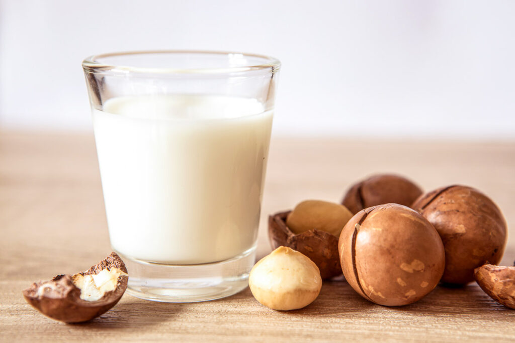 Close up a macadamia nut milk on wooden table , low fat healthy drink