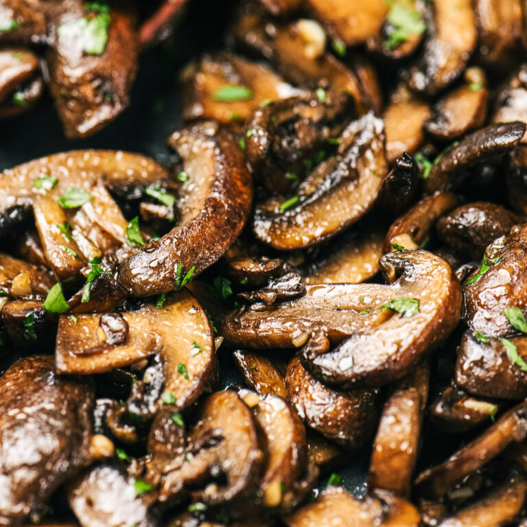 Sautéed mushrooms in a pan with herbs and oil